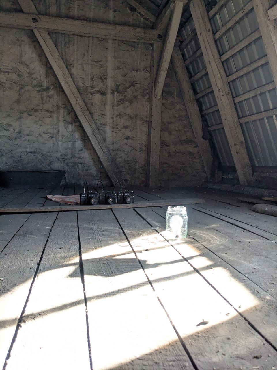 Trzy aparaty obok siebie na strychu, rejestrują żarówkę w słoiku