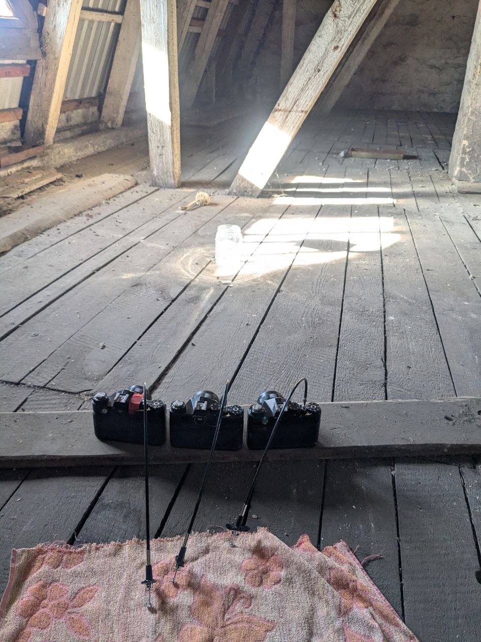 Trzy aparaty obok siebie na strychu, rejestrują żarówkę w słoiku